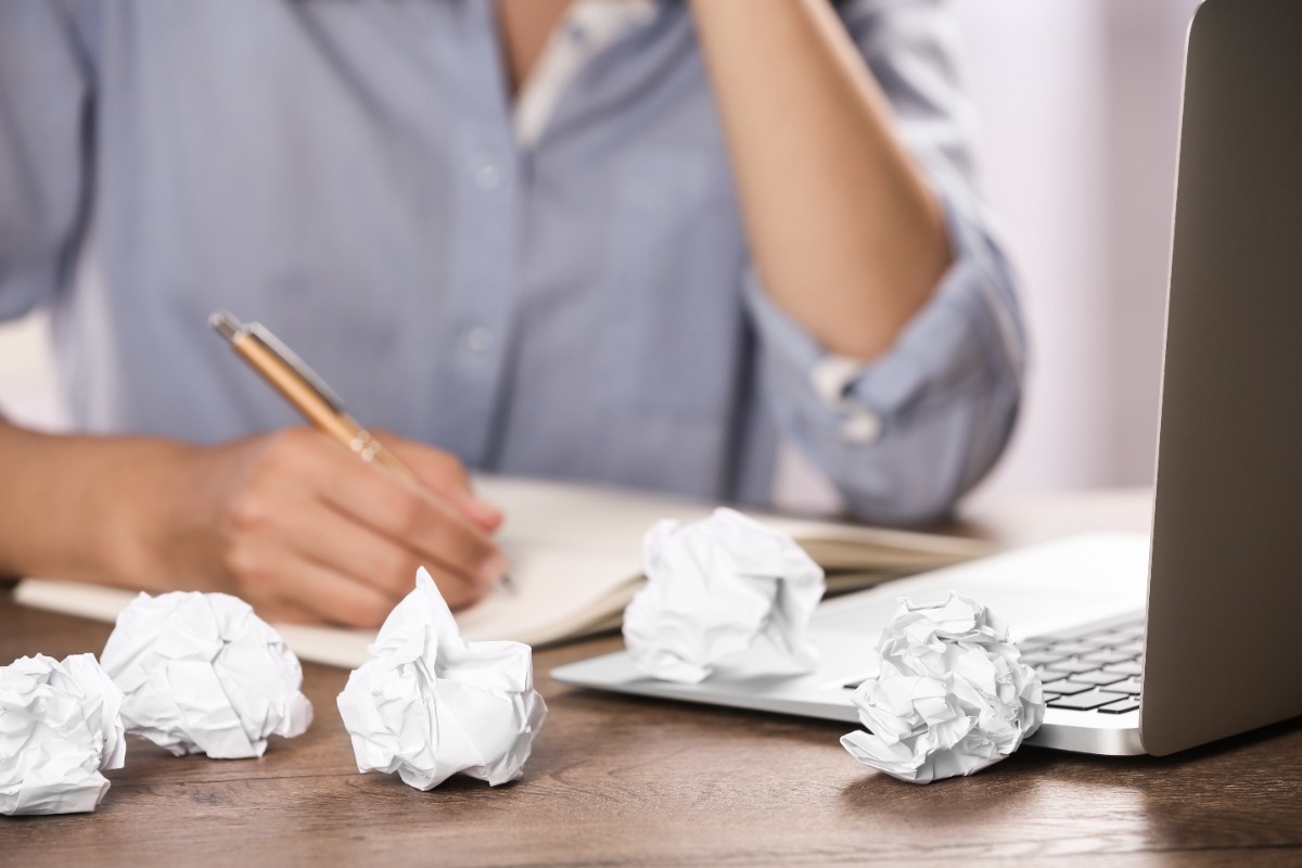 Woman working at table with crumpled paper