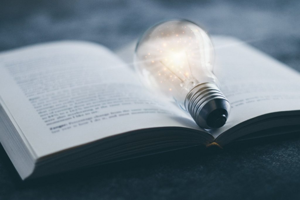textbook with glowing light bulb