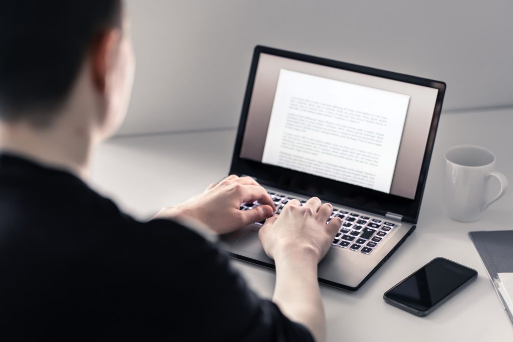 Man writing with laptop