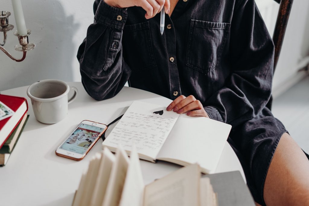 person writing on notebook