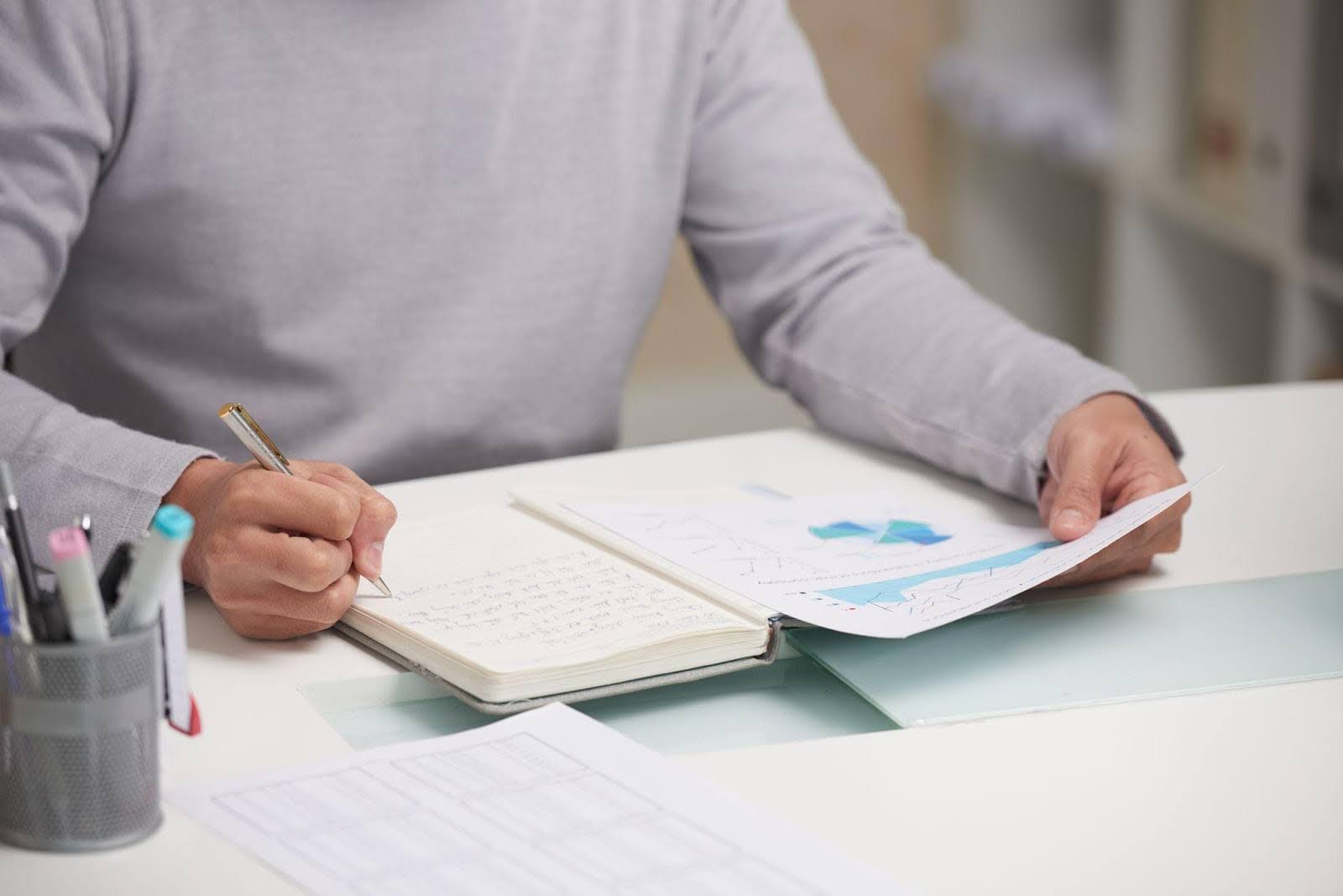 man writing in notebook